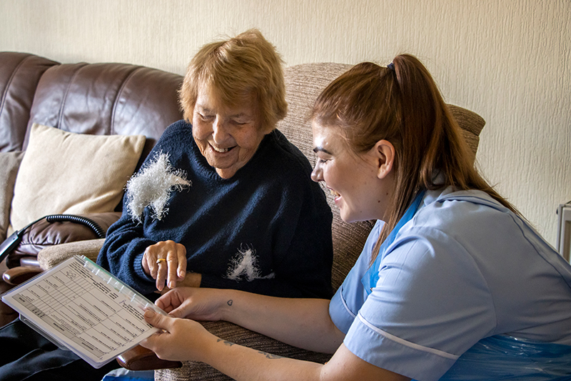 Carer talking to a patient in their front room