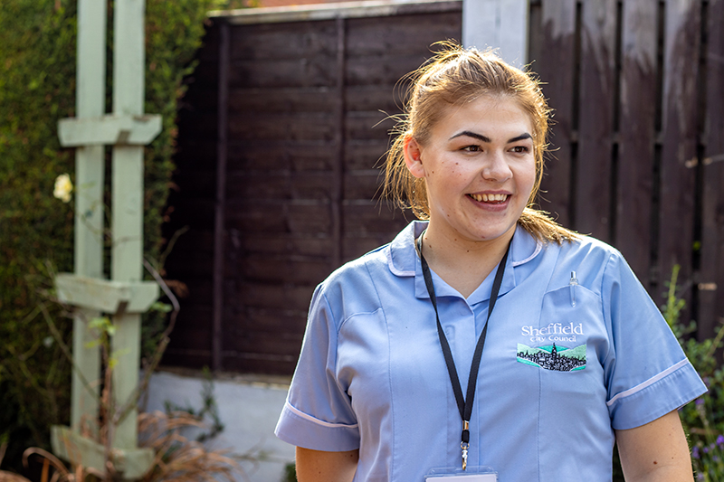 Care worker stood in a garden