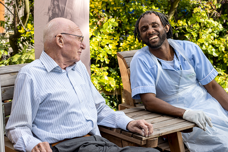 Carer and client sat talking in a garden