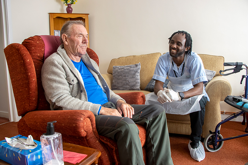 Carer talking to a patient in their front room