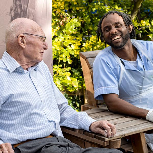 Carer and client sat talking in a garden