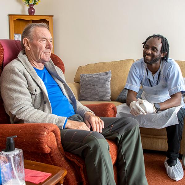 Carer talking to a patient in their front room